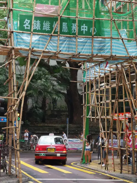 Red taxi through bamboo scaffolding in Tsim Sha Tsui